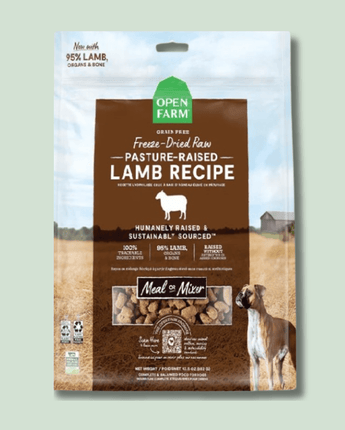 Package of Open Farm Freeze Dried Dog Food Pasture-Raised Lamb Recipe dog food, featuring 95% lamb, organs, and bone, labeled as humanely raised and sustainably sourced. The packaging shows an image of a dog next to a rural farm scene and product nuggets visible through a clear window.