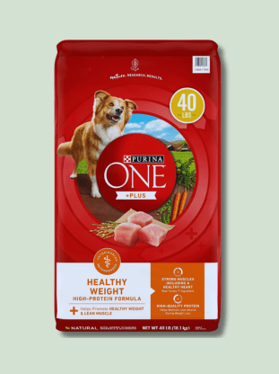 A red bag of Purina One Healthy Weight High-Protein Formula dry dog food, featuring an image of a smiling dog and pieces of chicken, weighing 40 pounds.