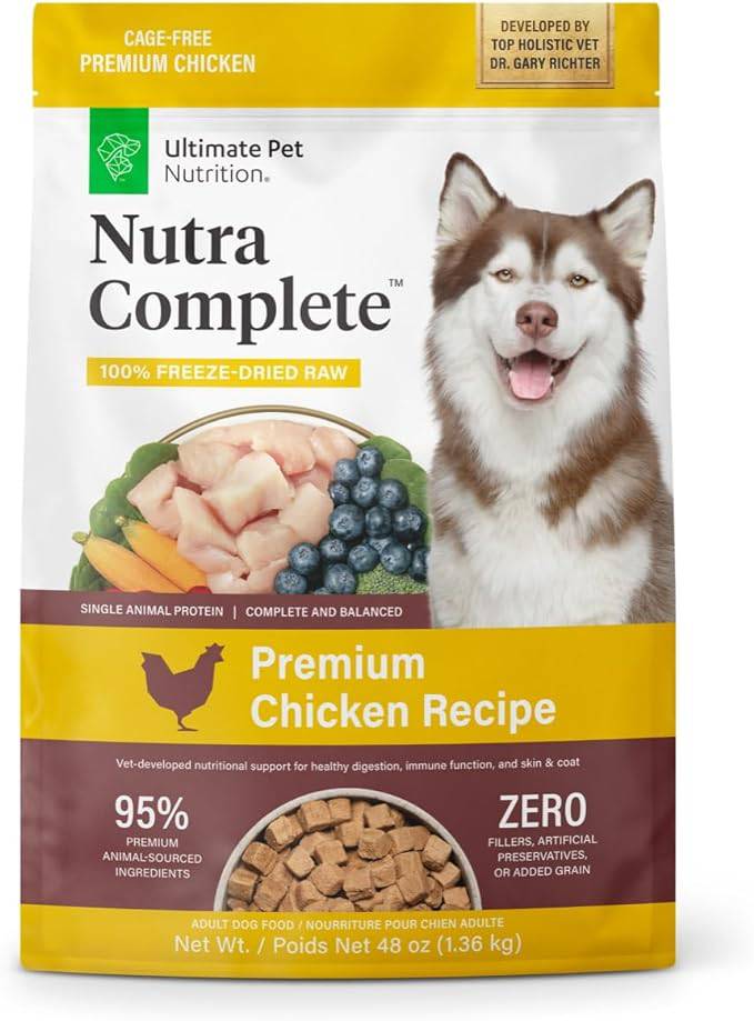 Packaging for Nutra Complete freeze-dried raw dog food with cage-free premium chicken, developed by holistic vet Dr. Gary Richter. The bag features an image of a smiling Alaskan Malamute and highlights the product as complete and balanced with 95% premium animal-sourced ingredients and no fillers, artificial preservatives, or added grain.