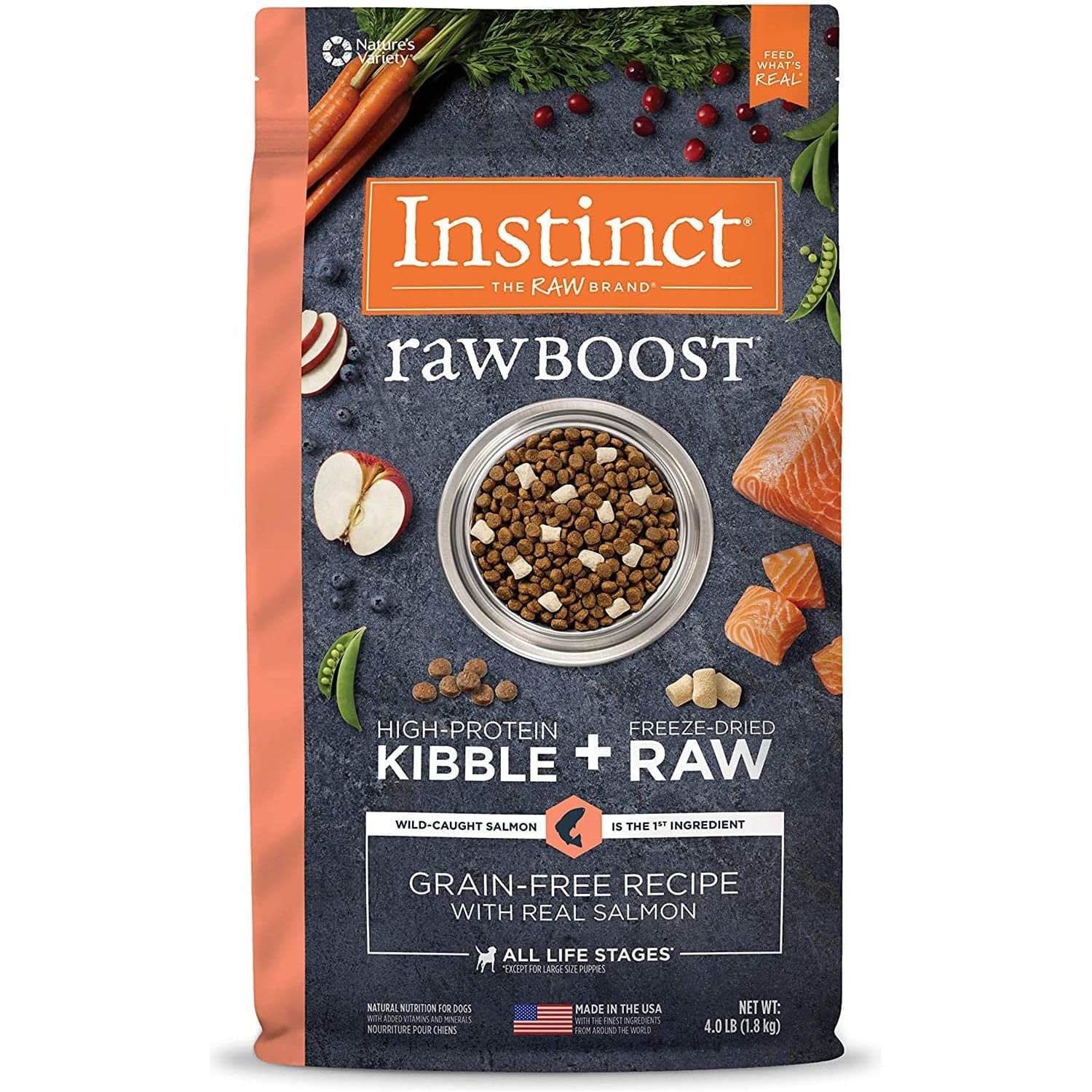 A package of Instinct Raw Boost high-protein kibble with freeze-dried raw pieces, featuring wild-caught salmon as the primary ingredient, grain-free recipe, and decorated with images of raw salmon, fresh vegetables, and herbs around a bowl of the kibble.