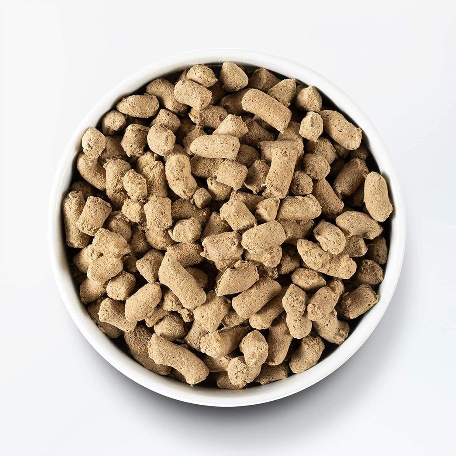 Top view of a white bowl filled with brown, textured dog food pellets, isolated on a white background.