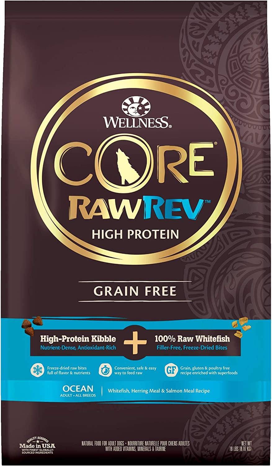 A bag of Wellness Core RawRev High Protein, Grain-Free dog food in "Ocean" flavor, featuring high-protein kibble and 100% raw whitefish freeze-dried bites. The packaging is dark brown with gold and teal accents, and includes the brand logo, product name, and images of the kibble and raw bites. It is made in the USA and weighs 18 lbs.