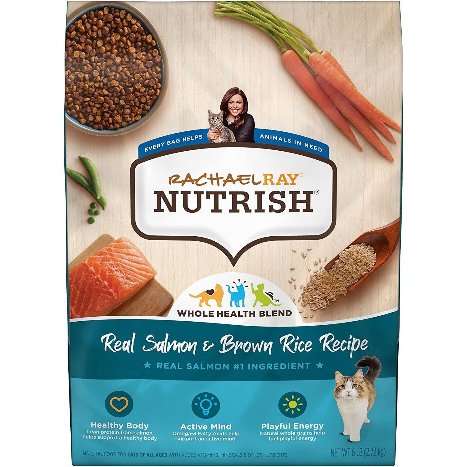 A bag of Rachael Ray Nutrish Whole Health Blend cat food with Real Salmon & Brown Rice Recipe. The packaging states that real salmon is the number one ingredient, and it promotes a healthy body, active mind, and playful energy. The package also indicates that every bag helps animals in need. The composition includes a bowl of dry cat food, fresh carrots, salmon, and a wooden spoon with brown rice scattered around.