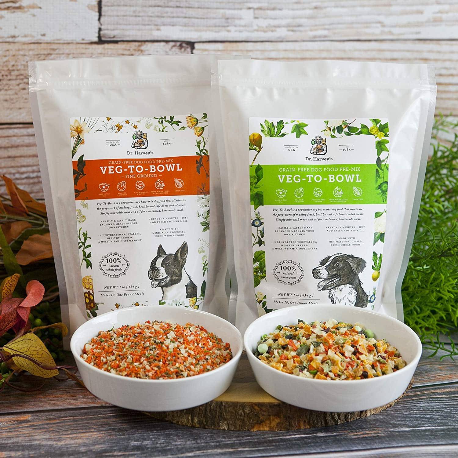 Two bowls of colorful dried dog food in front of two bags labeled Dr. Harvey's Veg-to-Bowl. One bag has an orange label and a drawing of a French Bulldog, the other has a green label and a drawing of a Border Collie.