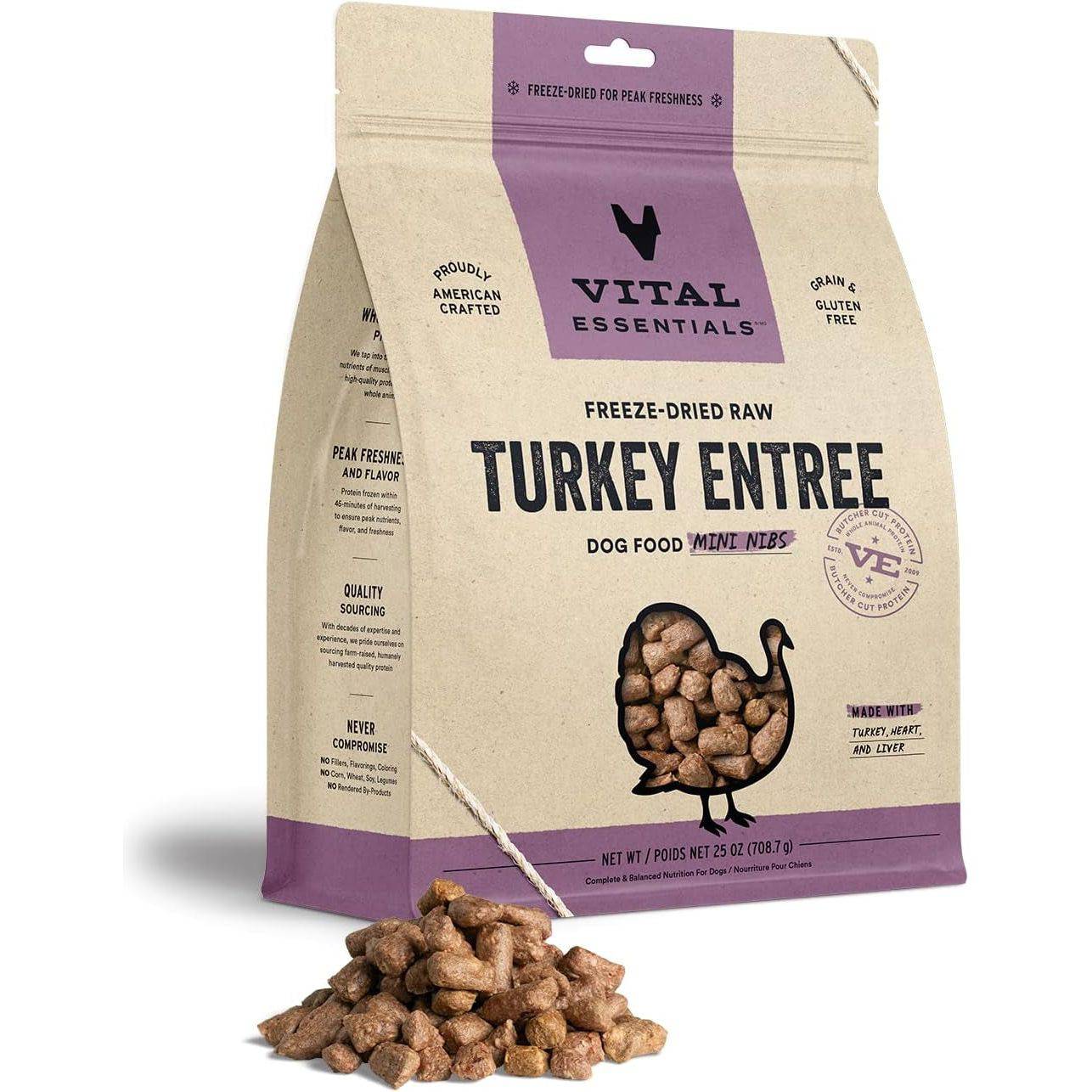 A package of Vital Essentials freeze-dried raw turkey entrée dog food with kibble spilled out in front. The packaging is predominantly beige with purple accents, and includes text details like "grain & gluten free" and the brand logo.