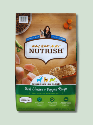 A package of Rachael Ray Nutrish Whole Health Blend dog food with real chicken and veggies recipe, showing the brand logo and an image of Rachael Ray with a dog. The package is green with pictures of carrots, peas, and chicken, indicating the ingredients in the food.