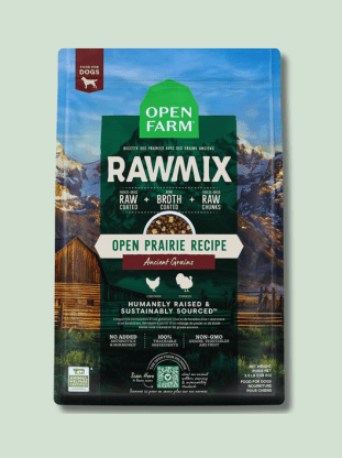 Package of Open Farm RawMix dog food featuring a mountainous prairie landscape background, labeled as "Open Prairie Recipe" with highlights such as "Humanely Raised," and "Sustainably Sourced." The package promotes raw broth and raw meat inclusions.