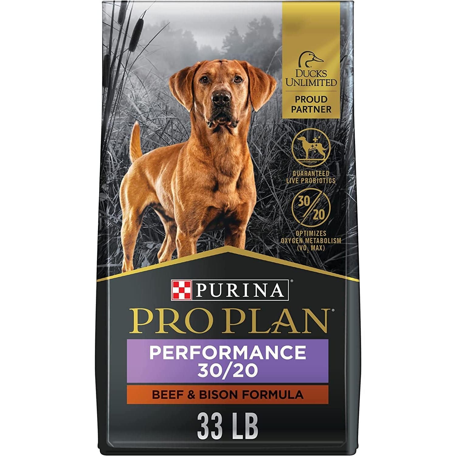 A bag of  Purina Performance 30/20 Beef & Bison Formula dog food, weighing 33 pounds. The packaging features gold and black design elements and the Purina logo on a grey background, along with a visual of outdoor scenery and graphical embellishments indicating a partnership with Ducks Unlimited.